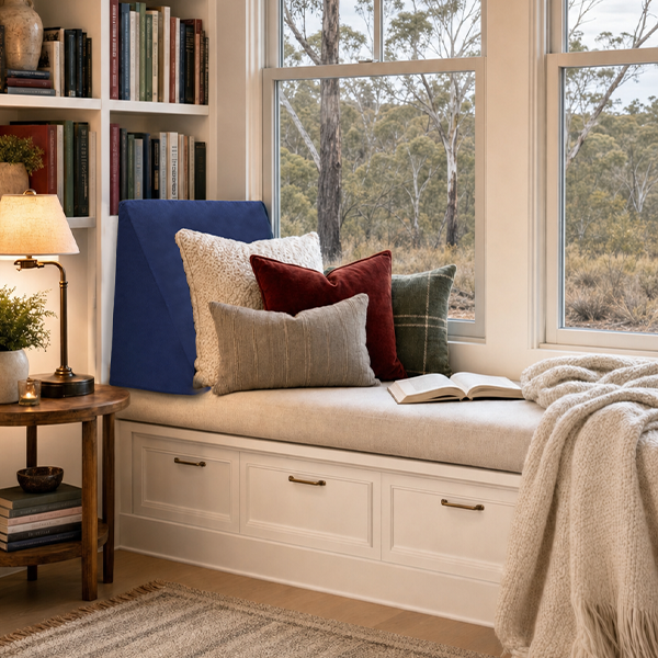 Cosy winter reading nook with soft lighting, textured cushions, and a foam backrest setup. 