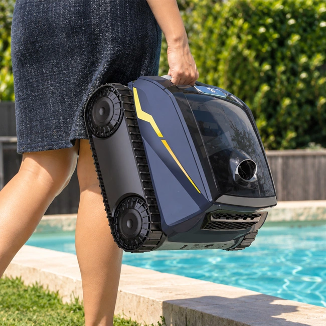 Zodiac FreeRider robotic pool cleaner being held beside a swimming pool