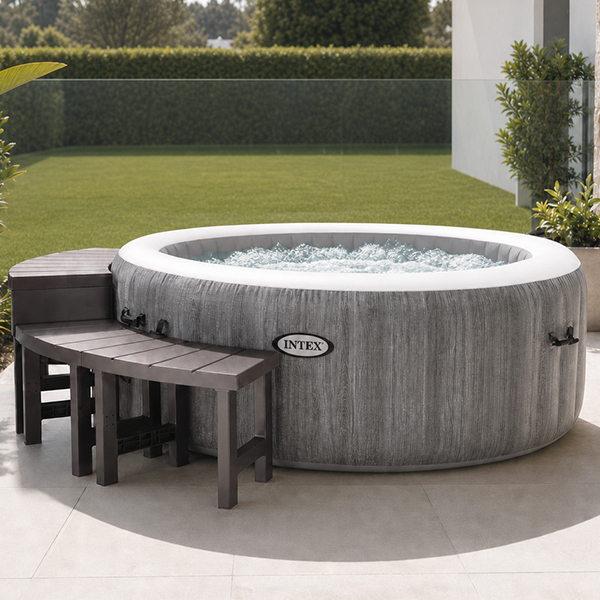 Backyard showing an inflatable spa with benches, tray, towels and potted plants. Inflatable spa relaxation zone using accessories instead of permanent landscaping.