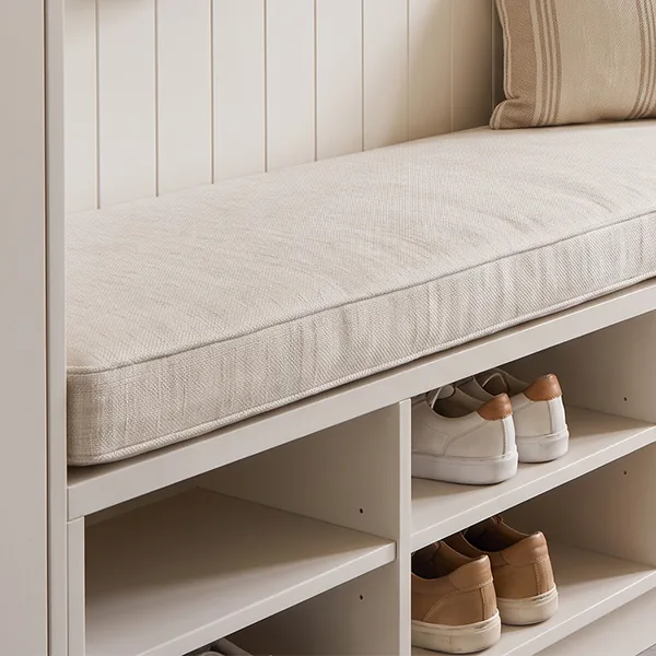 Close-up of custom made cushion on a mudroom bench with shoes stored underneath.